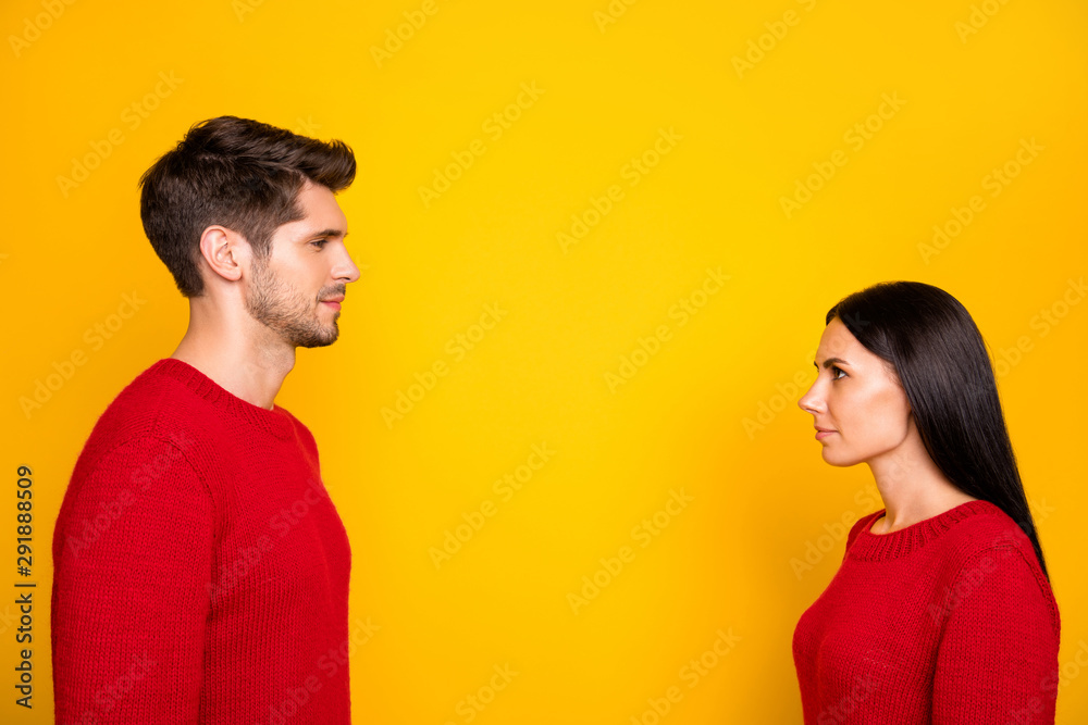 Profile side photo of concentared man and woman stare face-to face wear red pullover isolated over yellow background Profile side photo of concentared man and woman stare face-to face wear red pullover isolated over yellow background