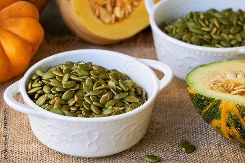 Peeled pumpkin seeds in white bowls 