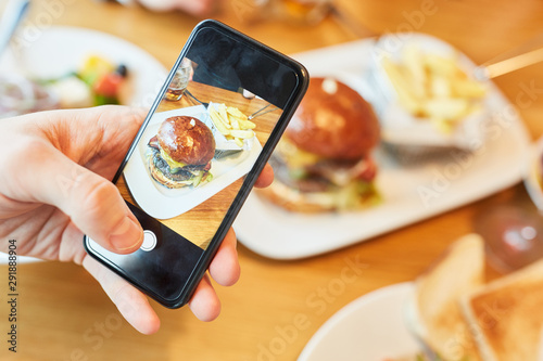 Hamburger Teller wird mit Smartphone fotografiert photo