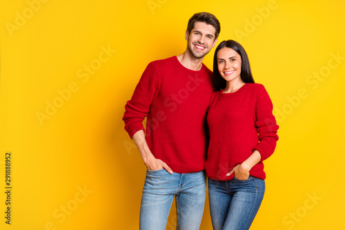 Portrait of lovely man and woman hug smile wear red pullover denim jeans stand isolated over yellow background © deagreez