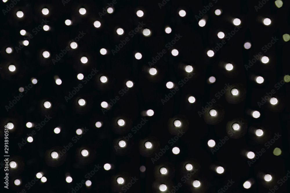 Silver lights with tint blurred bokeh, dark background with lots of flashing circles. Silver lights with tint blurred bokeh, dark background with lots of flashing circles.