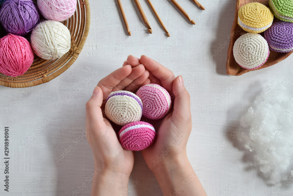 Making crochet amigurumi french macarons. Toy for babies or trinket.  Threads, needles, hook, cotton yarn. Handmade gift. Income from hobby. DIY  crafts concept. Photos | Adobe Stock