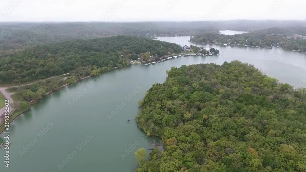 Drone flying over park with epic scenery of autumn colored trees and lake Drone flying over park with epic scenery of autumn colored trees and lake