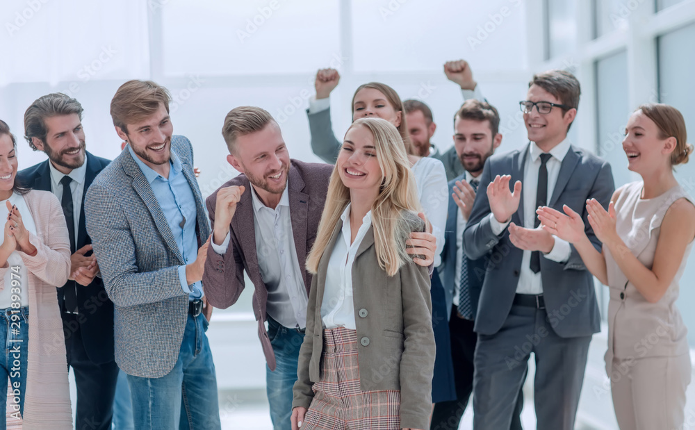 happy young woman standing in front of her jubilant colleagues happy young woman standing in front of her jubilant colleagues