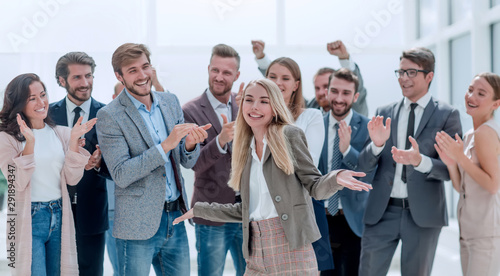 happy young woman standing in front of her jubilant colleagues