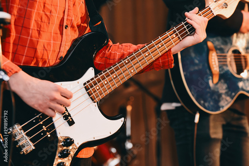 Guy playing bass guitar in a band. Fragment