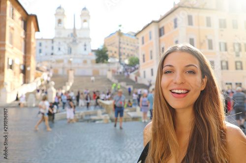 Close up of beautiful cheerful woman in Piazza di Spagna square in Rome with Spanish Steps and Barcaccia fountain on the background © zigres