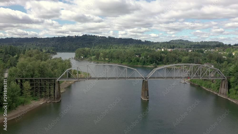rail bridge dolly over willamette river with clouds and blue skies.