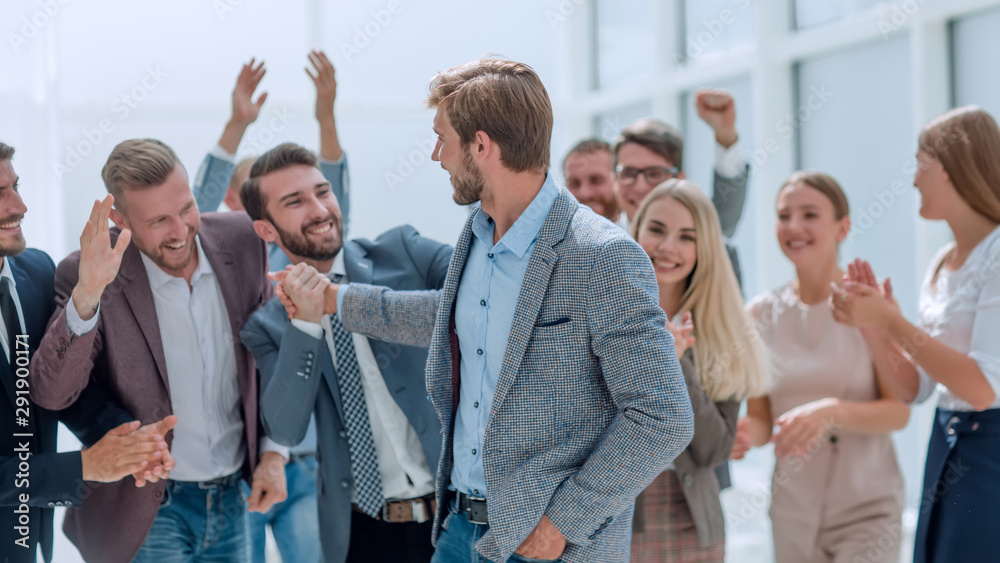 cheerful employees congratulating a colleague on the promotion