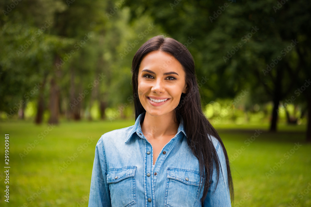 Portrait of charming lady looking at camera wearing denim jeans shirt outside Portrait of charming lady looking at camera wearing denim jeans shirt outside