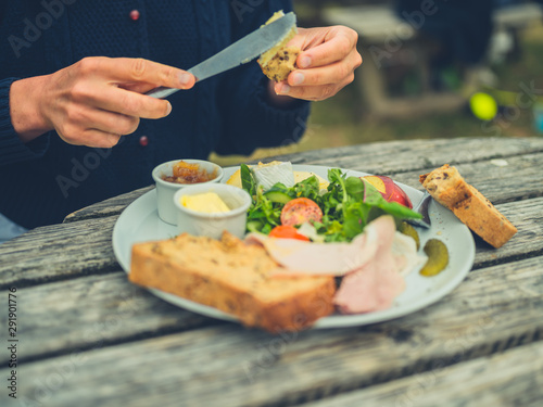 Woman buttering bread at picnic table