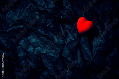 Red Heart on Wrinkled Dark Blue Background. Happy Valentine's Day, Love. Moody Romantic Halloween Concept.