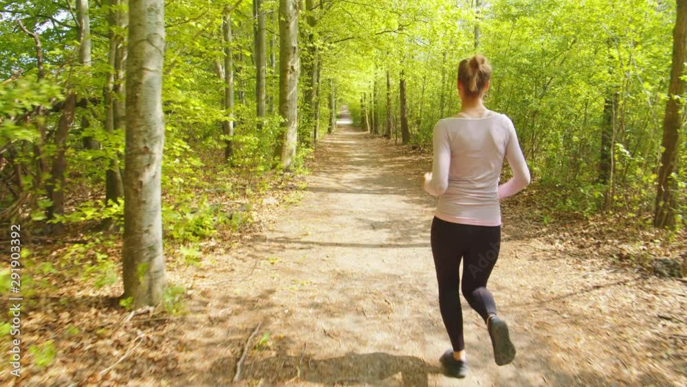 Woman Running On Forest Path Woman Running On Forest Path