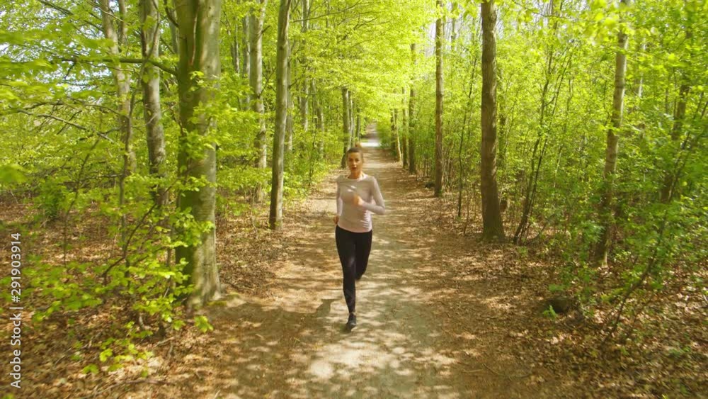 Smiling Woman Jogging In Forest