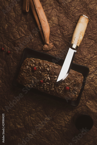 loaf of bread with a knife on a dark background