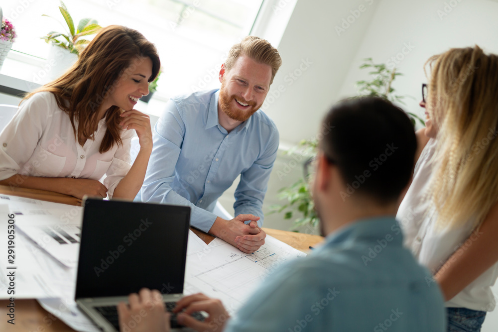Group of business people working and communicating while sitting at the office desk together Group of business people working and communicating while sitting at the office desk together