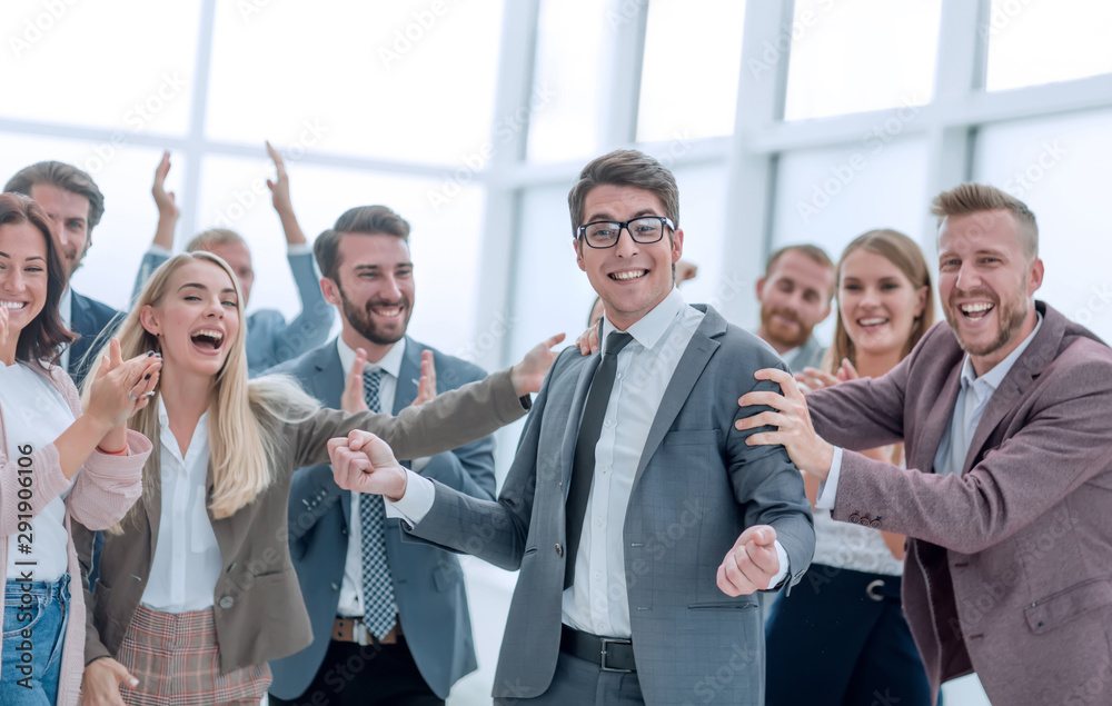 Obraz premium happy young businessman standing in front of his business team.