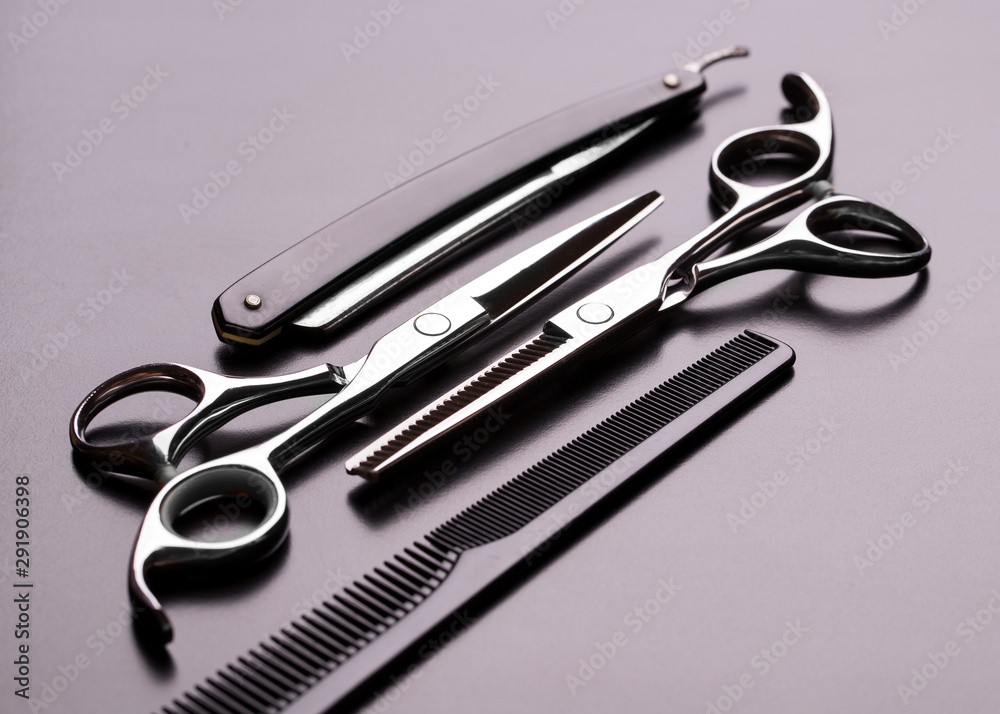 Barber tool close-up. Scissors, comb and razor on a dark background. Barber tool close-up. Scissors, comb and razor on a dark background.