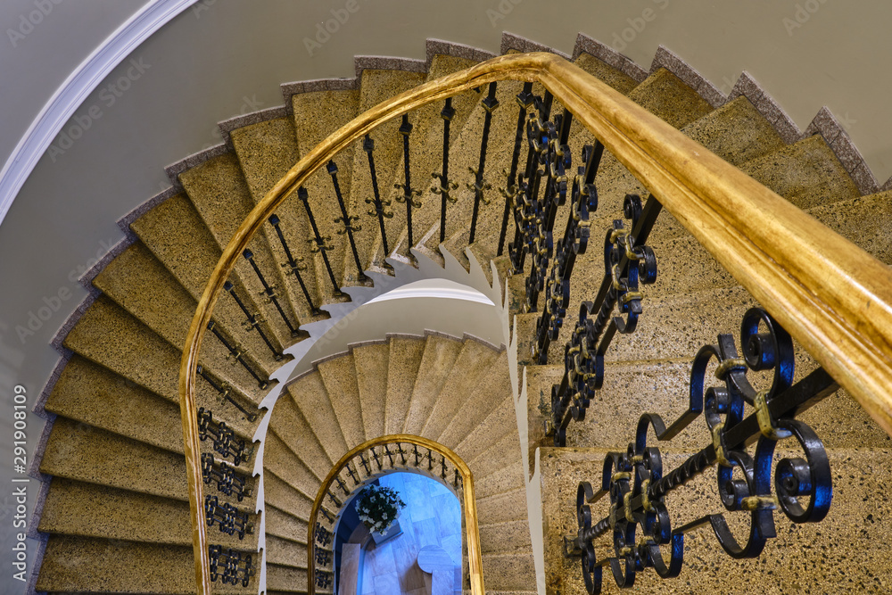Fototapeta premium Top down view of elegant, golden, spiral staircase.