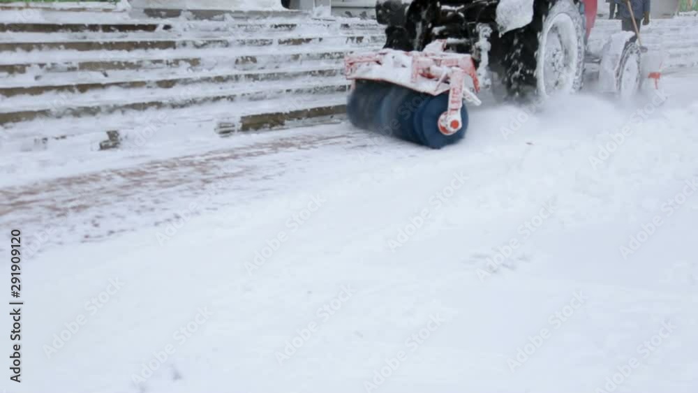 Snowplow removing fresh snow from city square. Tractor with snowplow equipment removing snow from streets in snow blizzard. Snowplow removing fresh snow from city square. Tractor with snowplow equipment removing snow from streets in snow blizzard.