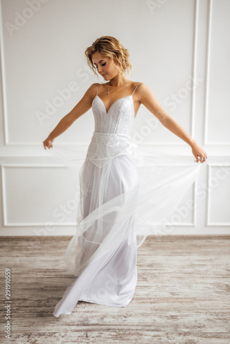 the bride in a beautiful dress is spinning in a white Studio