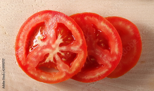 Tomato slices isolated on wooden chopping, cutting board, top view