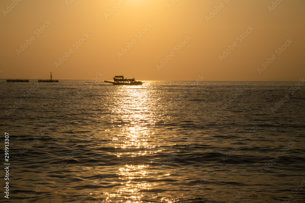 Boat at sunset in a sea during a beautiful colorful golden hour.