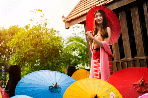 Portrait of happy young Asian woman holding red umbrella with copy space for Ad. text or product your. Cute cambodian girls. beauty ,Fashion concept