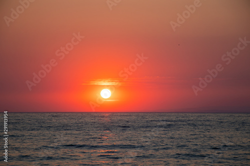 Fototapeta Naklejka Na Ścianę i Meble -  Sunset at sea during a beautiful golden hour. Landscape of the sun setting on the horizon.