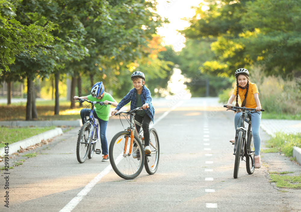Cute children riding bicycles outdoors Cute children riding bicycles outdoors