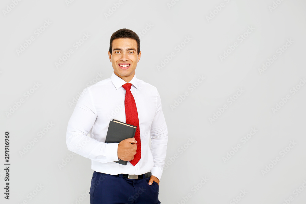 Handsome African-American businessman with book on white background Handsome African-American businessman with book on white background