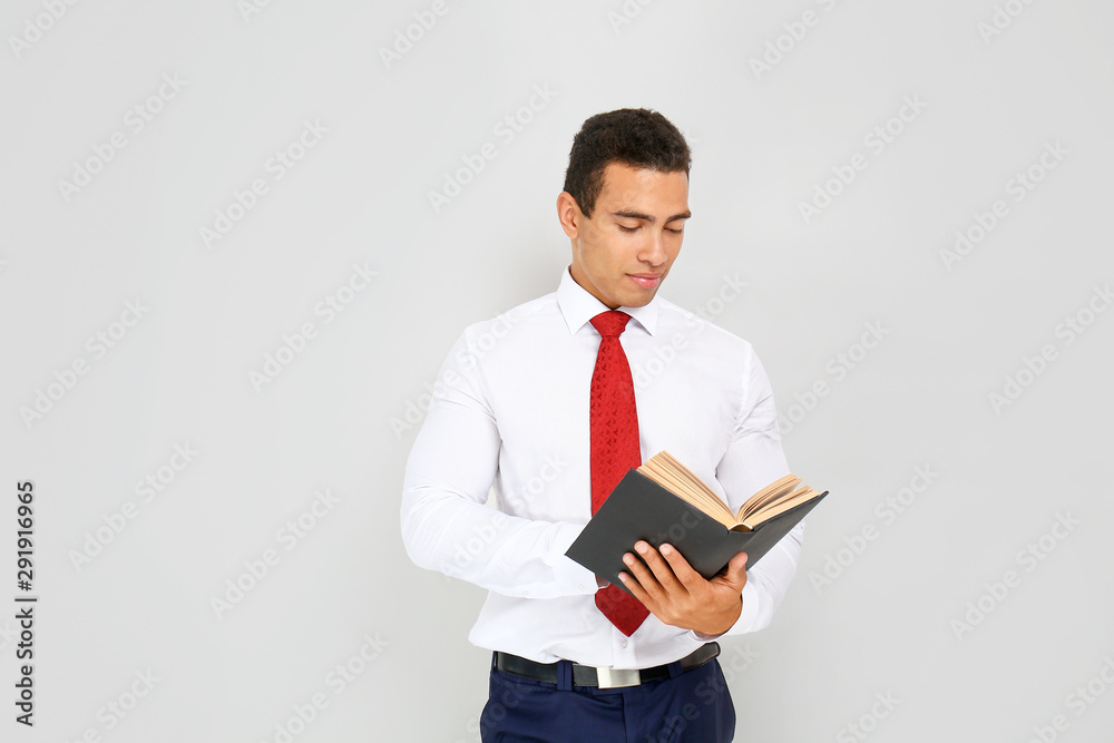Handsome African-American businessman with book on white background Handsome African-American businessman with book on white background