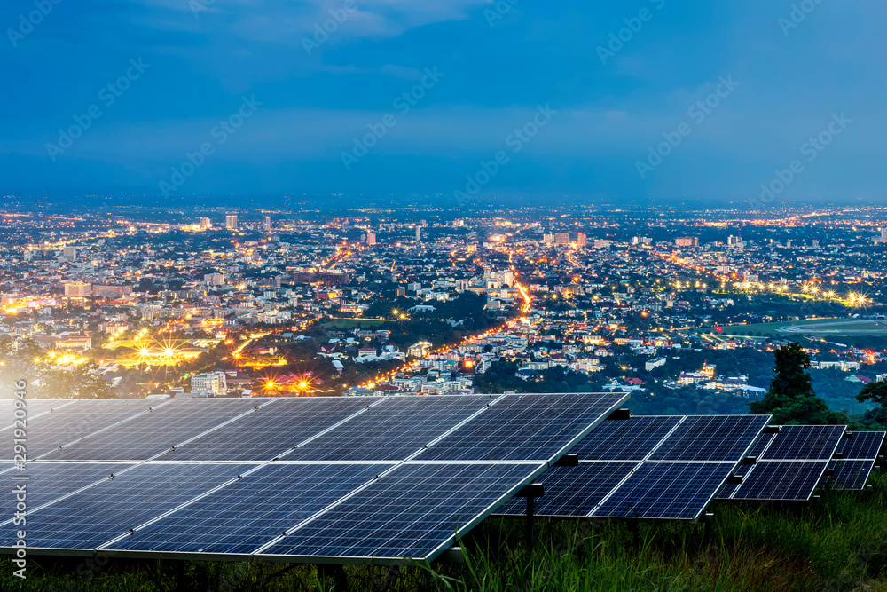 Solar panel with city night architecture electric energy light background,clean Alternative power energy concept.