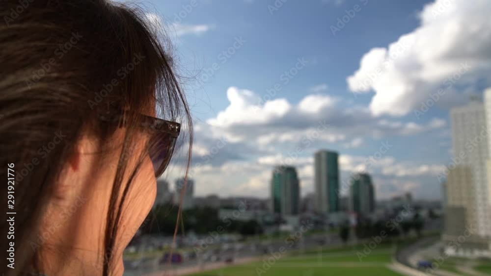 pretty lady in blue denim jacket looks at modern city buildings and straightens long hair slow motion close view pretty lady in blue denim jacket looks at modern city buildings and straightens long hair slow motion close view