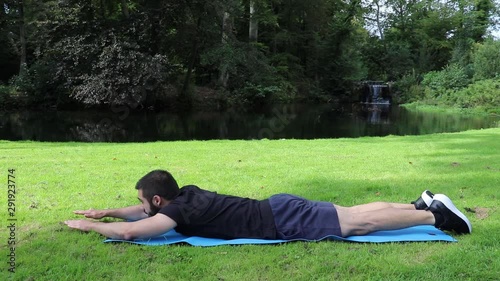 Man training lower back superman in park