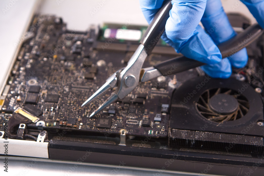 Naklejka premium fixing a hard disk drive with one hand with gloves and a special tweezers