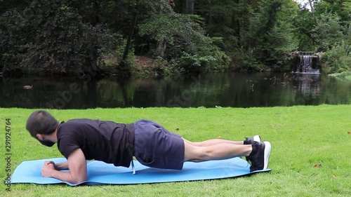 Man doing spiderman plank in park