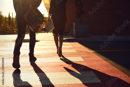 Back view. Business People walk along the city street.