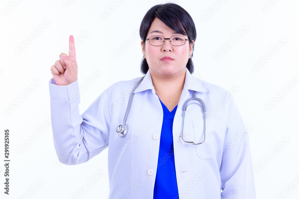 Beautiful overweight Asian woman doctor pointing up Beautiful overweight Asian woman doctor pointing up