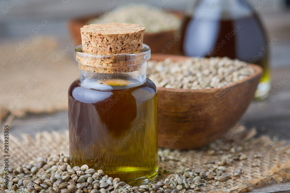 Organic hemp oil and hemp seeds on rustic background Organic hemp oil and hemp seeds on rustic background