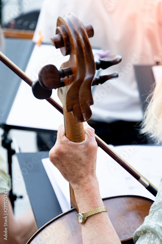 Cropped image of a back turned woman playing cello