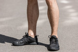 cropped view of sportsman in black sneakers on street