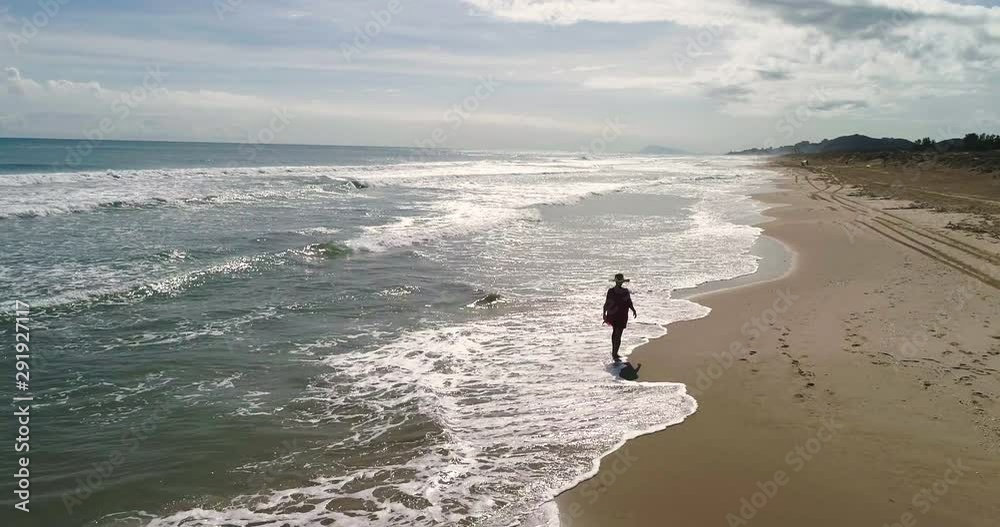 Mujer con pamela pasea en solitario en playa paradisiaca Mujer con pamela pasea en solitario en playa paradisiaca