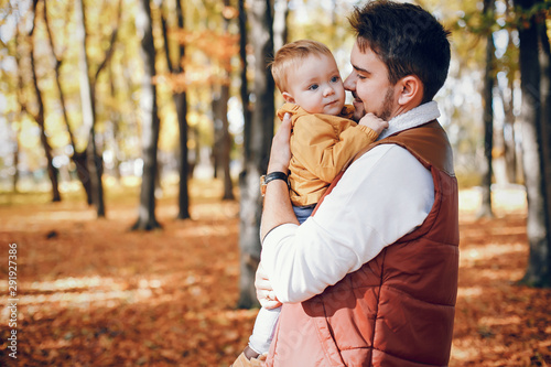 Family have fun in a autumn park. Handsome fathe with little son