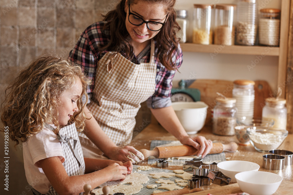 Fototapeta premium Mother and daughter playing and preparing dough in the kitchen.