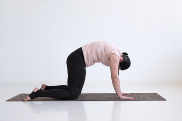 Woman doing yoga asana bitilasana cow or cat pose for gentle warm up for spine