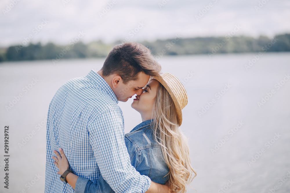 beautiful long-haired blonde with her handsome man wallkinh near water on the beach