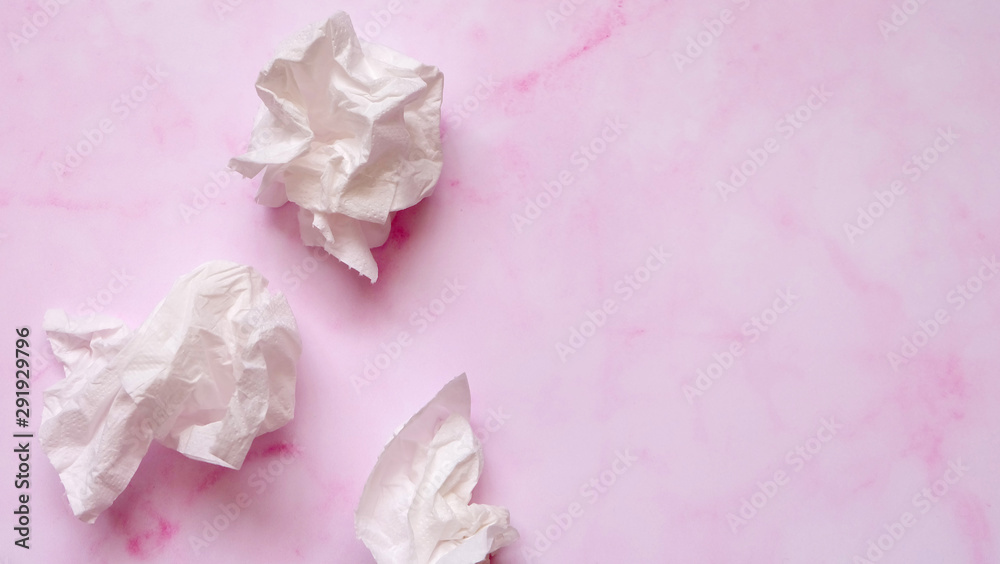 Fototapeta premium White crumpled tissue paper on a pink marble background.