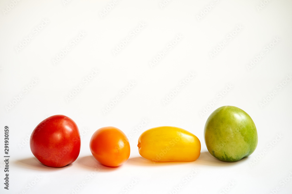 red, green and yellow tomatoes on white background red, green and yellow tomatoes on white background