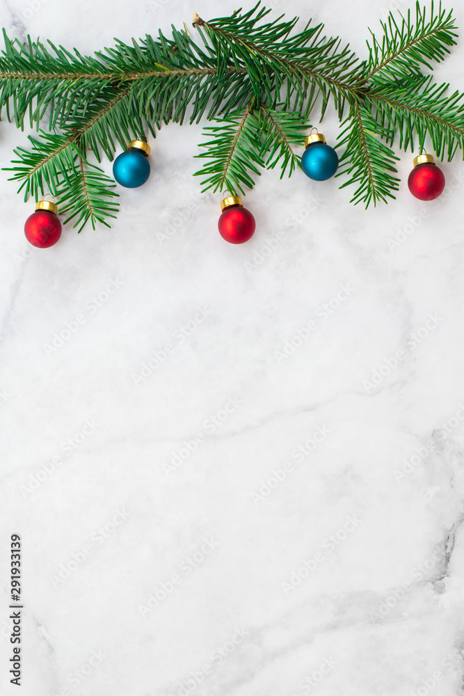 Fir-tree branches decorated with red and blue balls on gray marble background. New Year, Christmas and winter concept. Flat lay, top view, free copy space. Fir-tree branches decorated with red and blue balls on gray marble background. New Year, Christmas and winter concept. Flat lay, top view, free copy space.